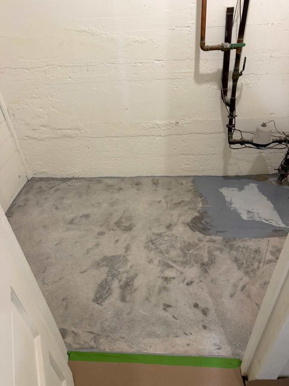 Basement utility room · sealed flake floor — before coating